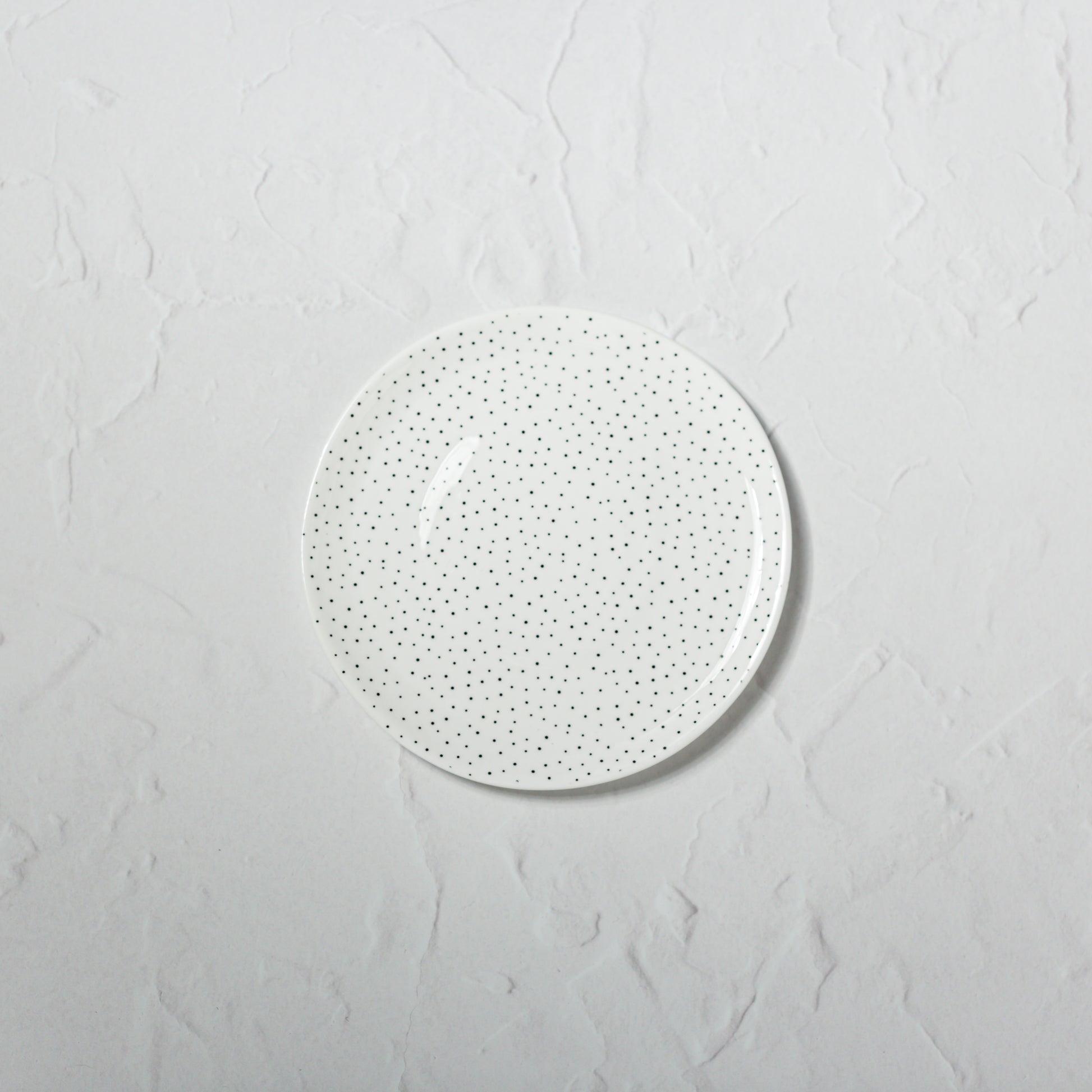 Small bone china plate by Emma Alington with a black dotted pattern.