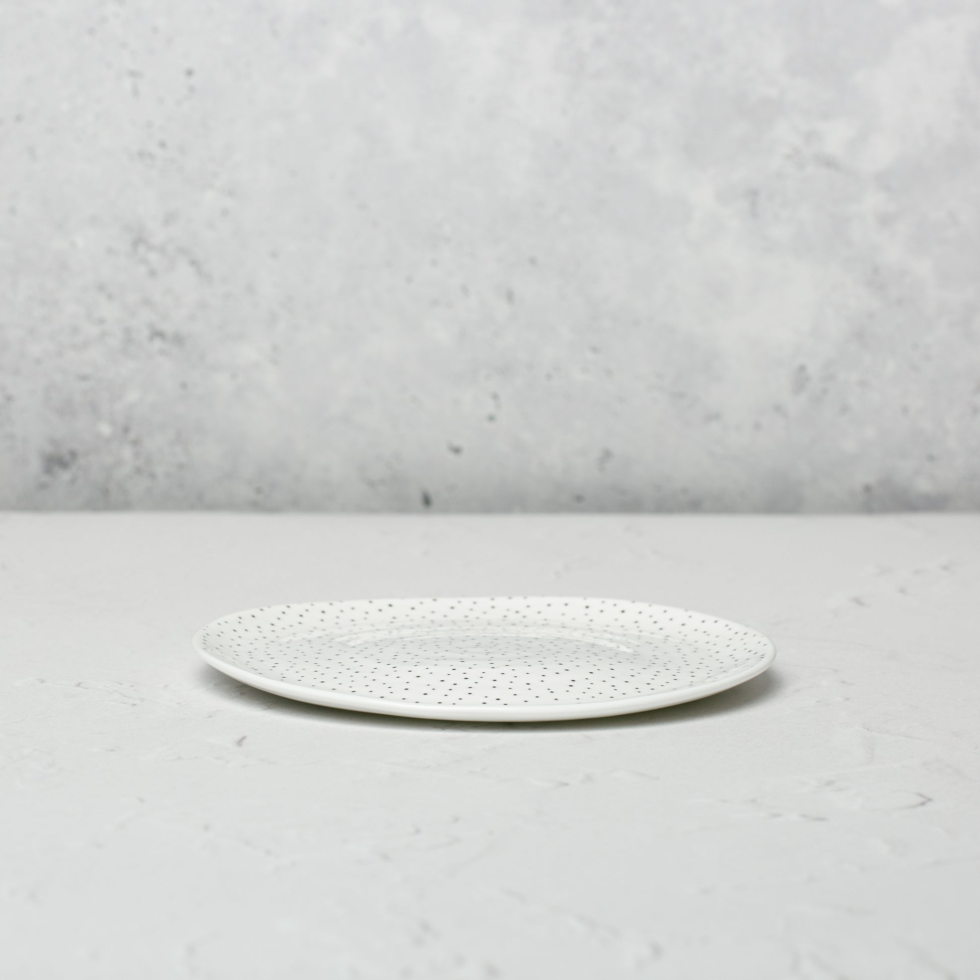 Small bone china plate by Emma Alington with a black dotted pattern.