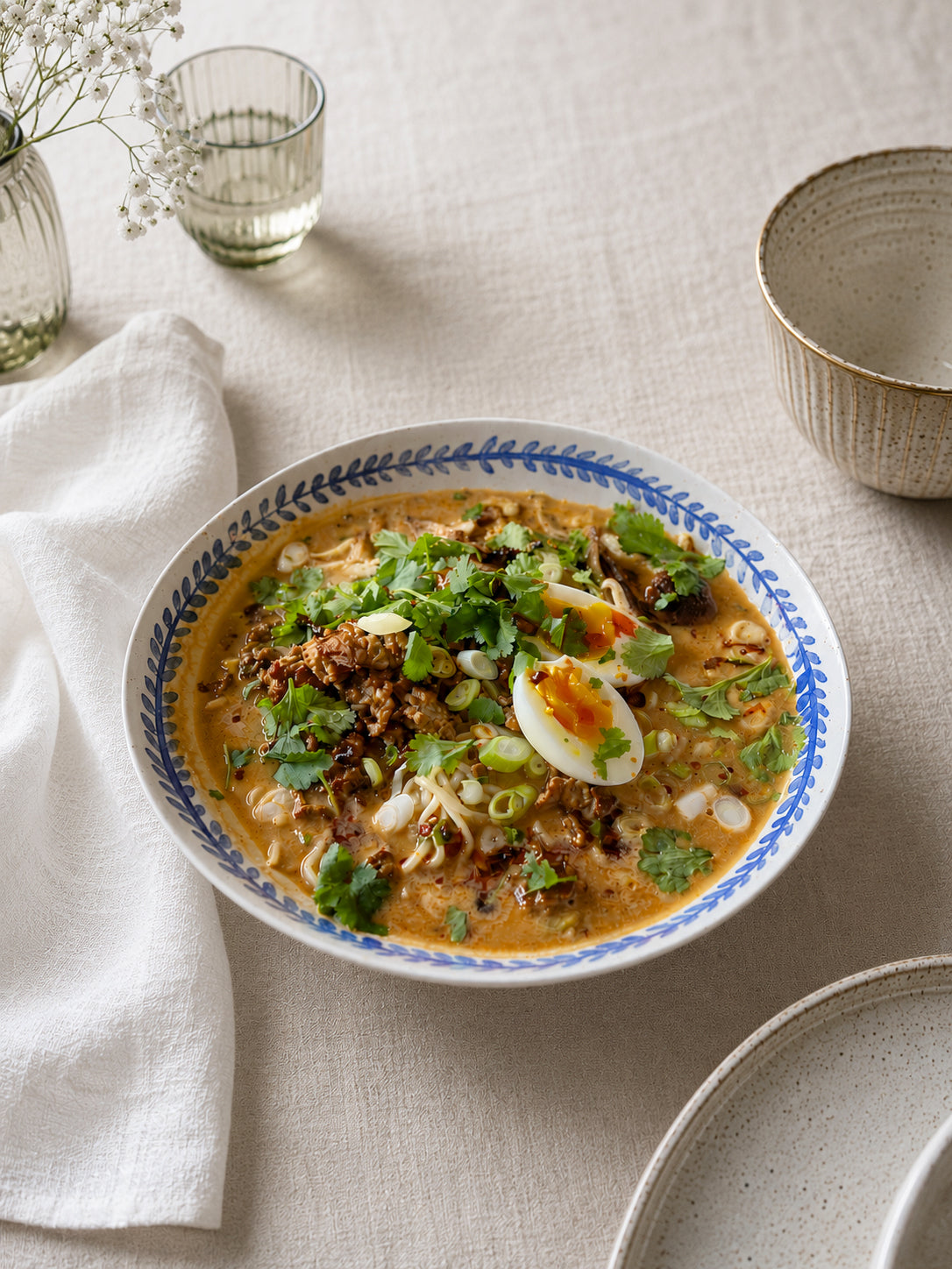 Handmade stoneware pasta bowl styled on a natural linen tablecloth, homemade ramen.
